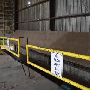 Barrier gates inside a garage. One of two metal pins is bent