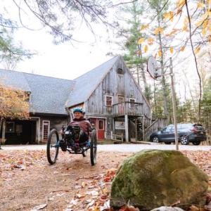 Woman rides an adaptive mountain bike away from a building