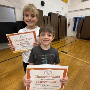 Two boys hold certificates