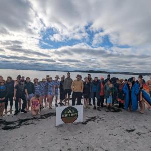 Large crowd of participants pose for a picture on the beach