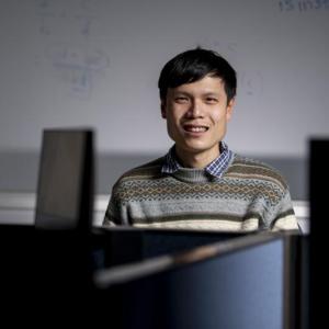 Male between computers, dry erase board