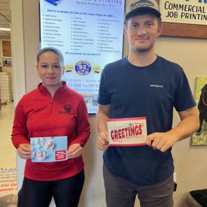 Female and male hold greeting cards