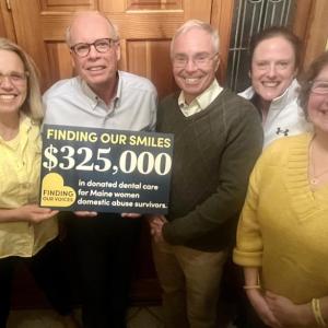 five adults and holding a sign