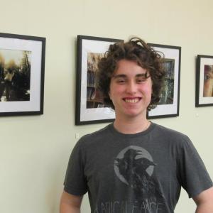 Finlay Donaghy standing before his art exhibit at Gibbs Library. Photo by Kay Stephens