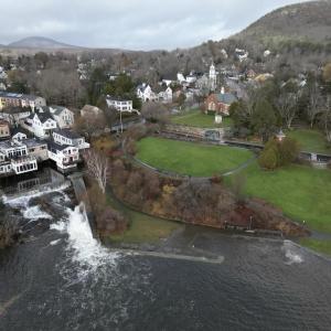 Photo taken in November 2023 during a stormy high tide event when the Camden Harbor Park seawall was breached and the shoreline flooded. Also pictured is the Megunticook River spillway and Montgomery Dam below the downtown commercial district.