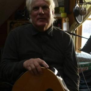 Philip Austin seated holding guitar