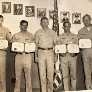 Group photo of five soldiers and their certificates