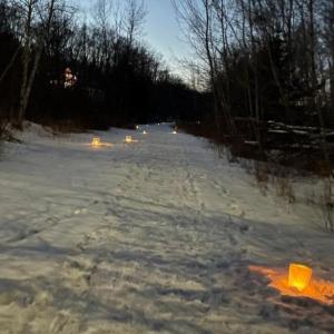 snow-covered trail with luminaries along the path