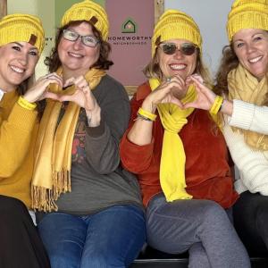 Four women combine hands for heart gestures