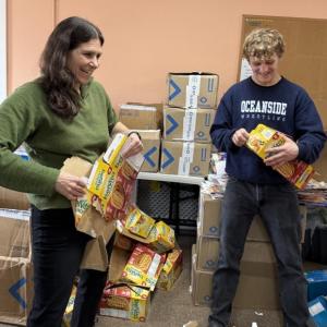 Woman, teenage boy flatten cardboard food packages