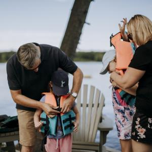 Adults helping children into life jackets