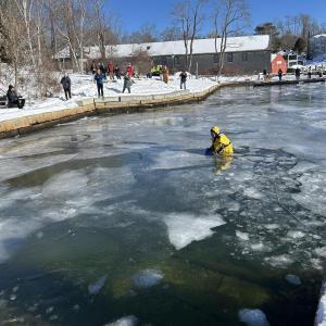 Camden Firefighter Derek Jay, in a cold water rescue suit, positions in the water for precautions. (Photo by Lynda Clancy)