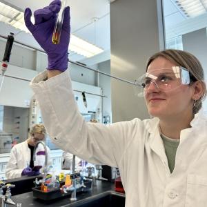 female holds up test tube in laboratory