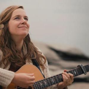 Alice Limoges strumming guitar