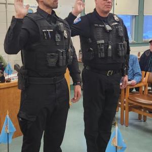 two officers raise their right hands