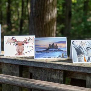 Four cards displayed on a wooden railing