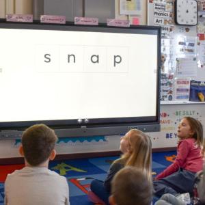 kids looking at a screen that displays the word 'snap'