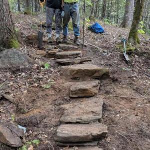 Two men stand at top of rock steps