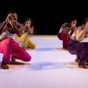 four dancers at a crouch