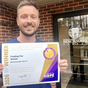 Robert Belanger holds Purple Ribbon Award certificate
