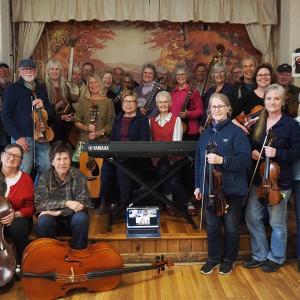 band members pose with instruments on small stage