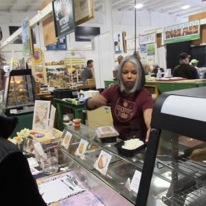 Concepta serving customers at her food stand. Photo by Kay Stephens