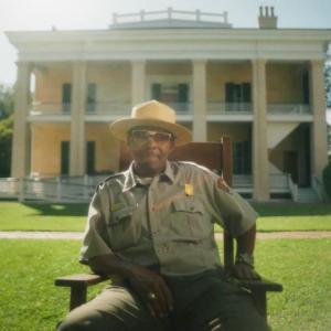 man in uniform in front of house