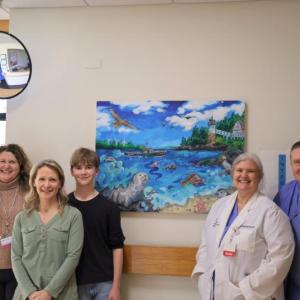 People pose in front of Peaceful Beginnings painting
