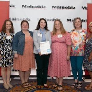 Six women pose in front of MaineBiz backdrop