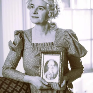 woman in costume holding framed portrait