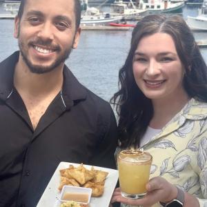 Man, woman hold appetizer, drink