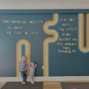 children lean against a decorated wall