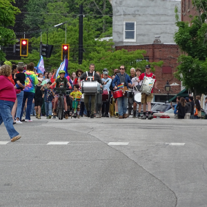 The start of the parade comes into view as beating drums announce their arrival. 