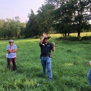 four adults standing in a field