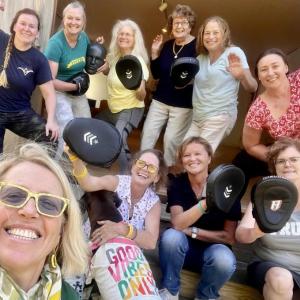group selfie of women wearing punching mitts