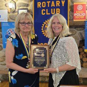two women stand with plaque