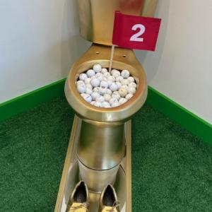 golden toilet with golf equipment