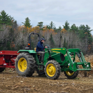 green tractor pulling red trailer