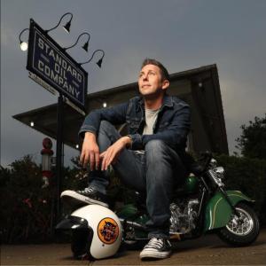man sits on miniature motorcycle
