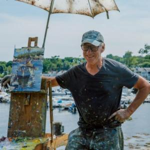 man poses with his painting