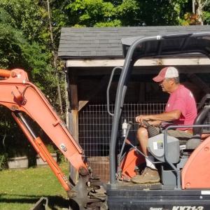 man operates backhoe