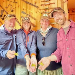 four people holding fishing lures
