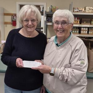 Goose River Golf Club Ladies League Manager Faith Vautour (R) presents a $1,000 check to Penny Baum, vice president of the Camden Area Christian Food Pantry Board of Directors.