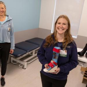 two women hold boot models