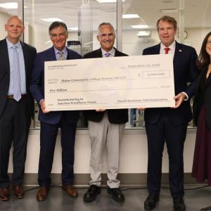 six adults pose with presentation check