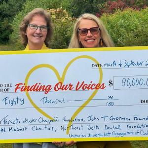 two women pose with presentation check