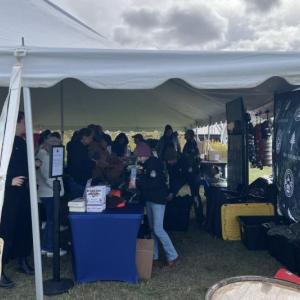 attendees stand in line, waiting to approach a table