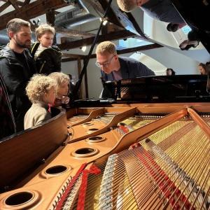 children look at piano strings