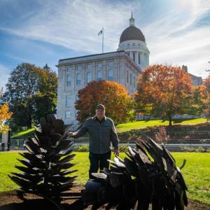 man, sculptures, capitol building in background